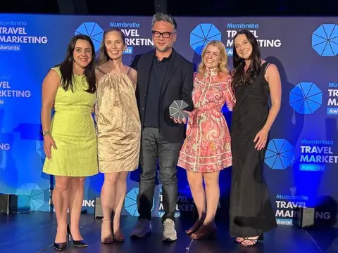 Award winners holding the PR Idea of the Year trophy for the Odd Jobs campaign at the Mumbrella Travel Marketing Awards