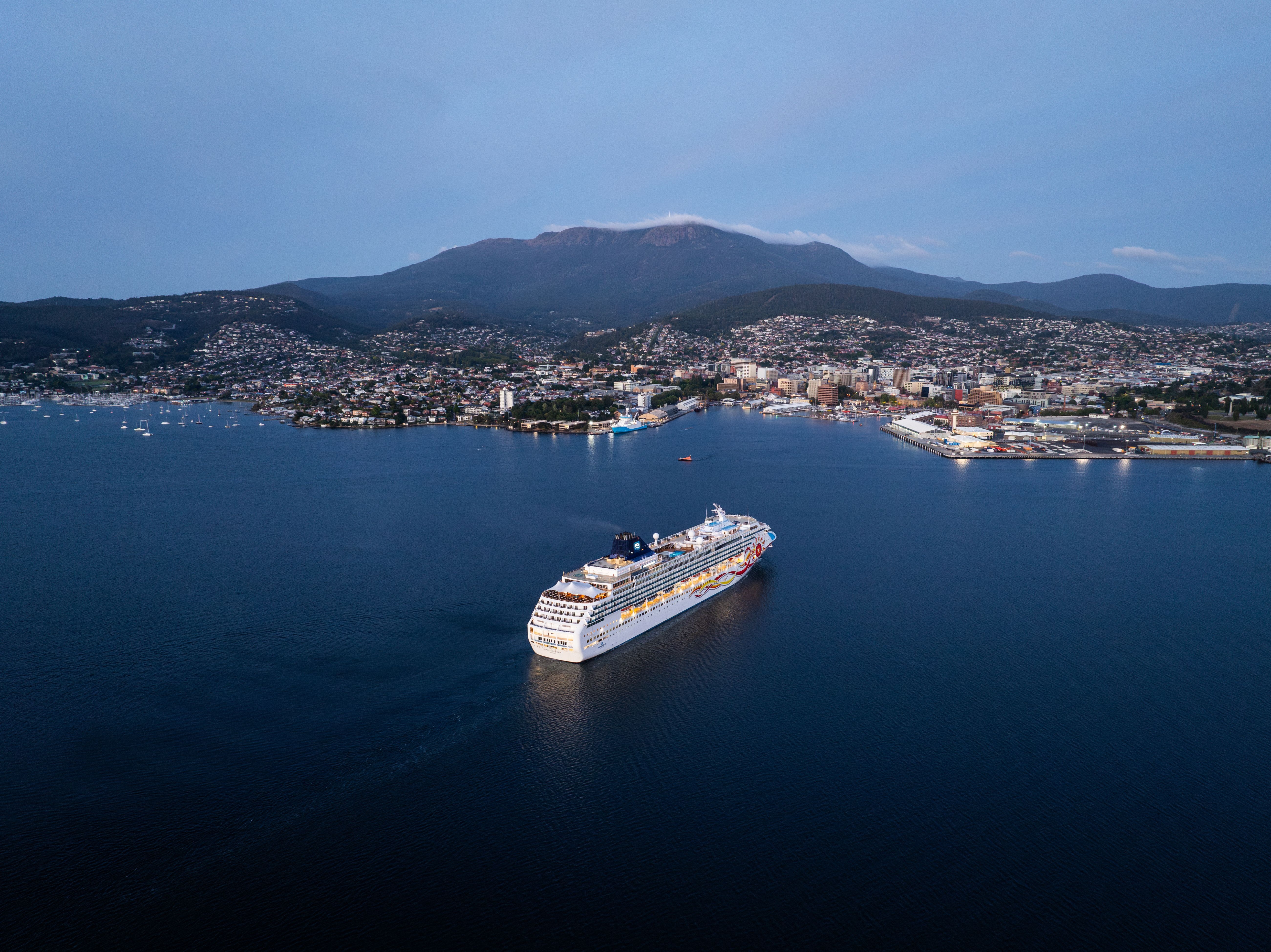 Aerial view of a cruise ship on the River Derwent approaching Hobart with the city below kunanyi / Mount Wellington