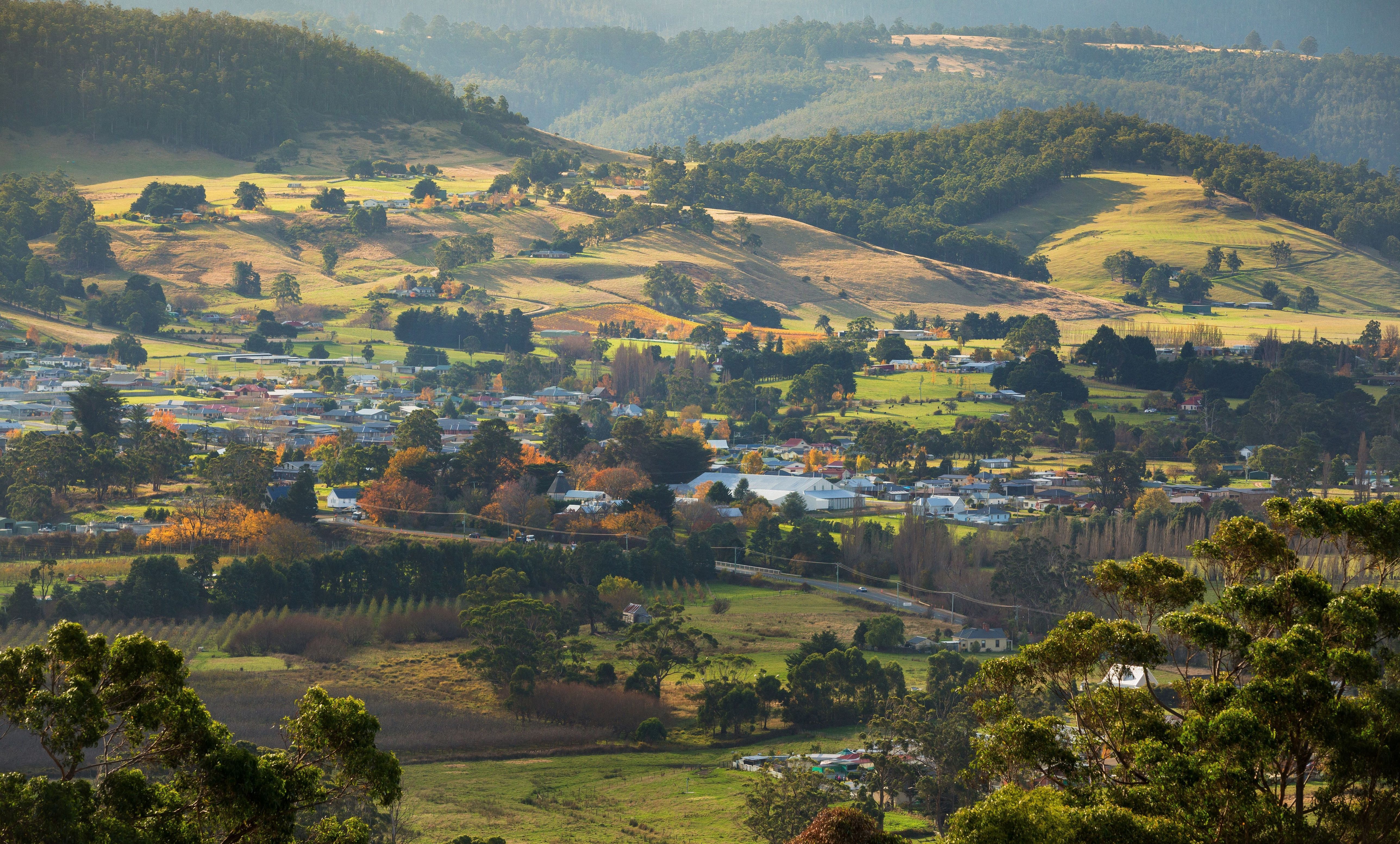 Elevated view over the town of Huonville among farmland and forested hills in the Huon Valley