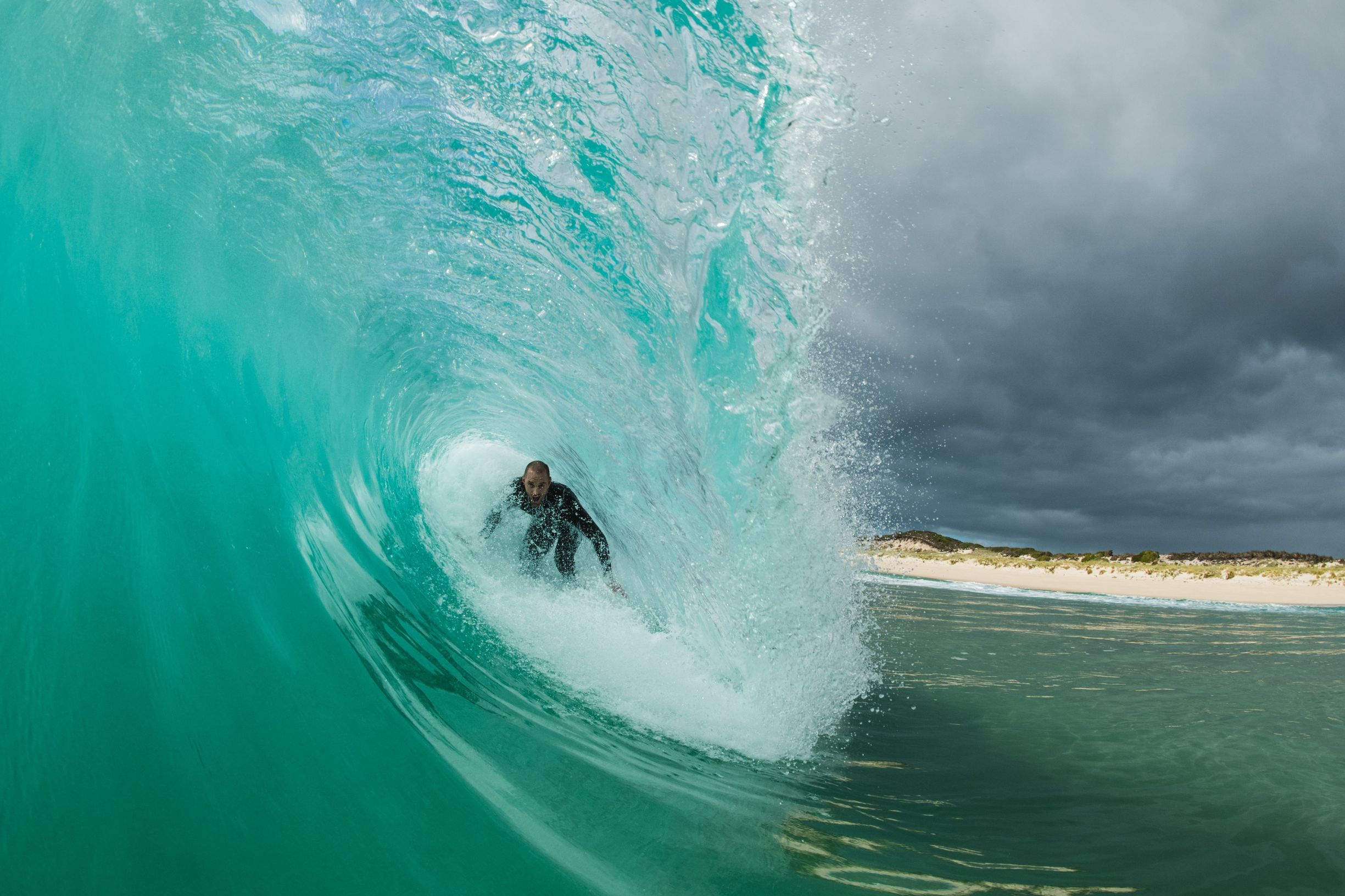 Surfer riding inside a wave's barrel at Martha Lavinia Beach, King Island