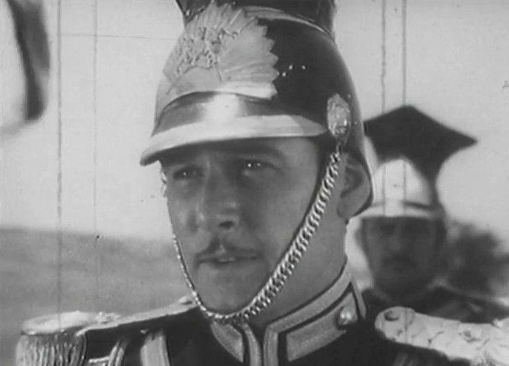 Video screengrab from the 1989 Errol Flynn campaign featuring a man in ceremonial military uniform with plumed helmet