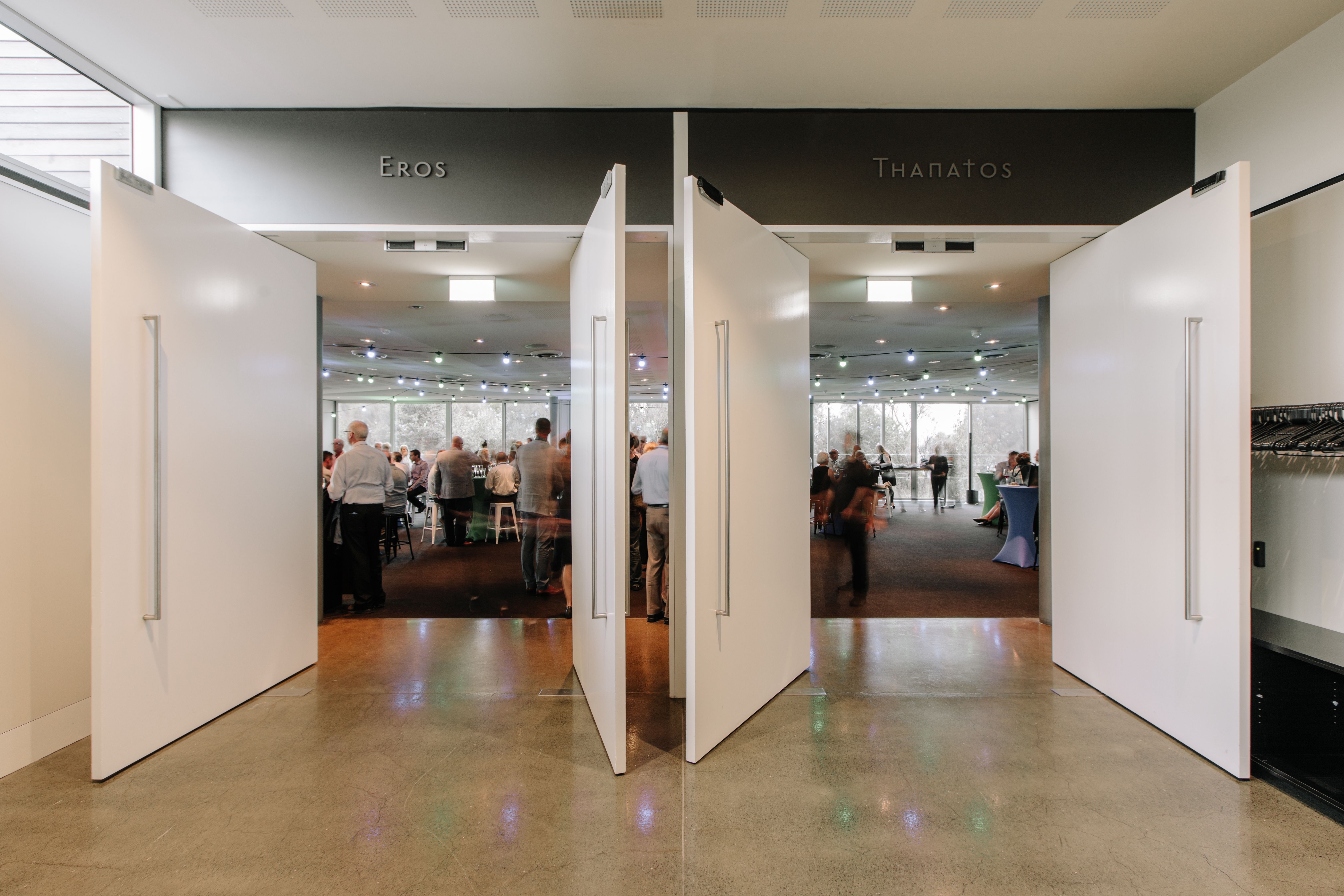 Guests in an event space viewed through doors labelled Eros and Thanatos at the Museum of Old and New Art (Mona), Berriedale