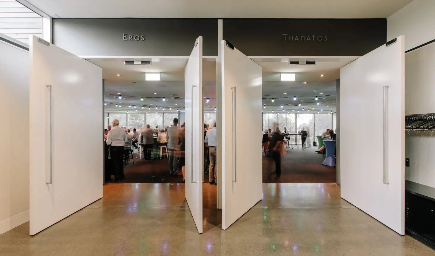 Guests in an event space viewed through doors labelled Eros and Thanatos at the Museum of Old and New Art (Mona), Berriedale