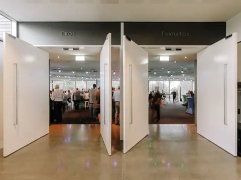 Guests in an event space viewed through doors labelled Eros and Thanatos at the Museum of Old and New Art (Mona), Berriedale