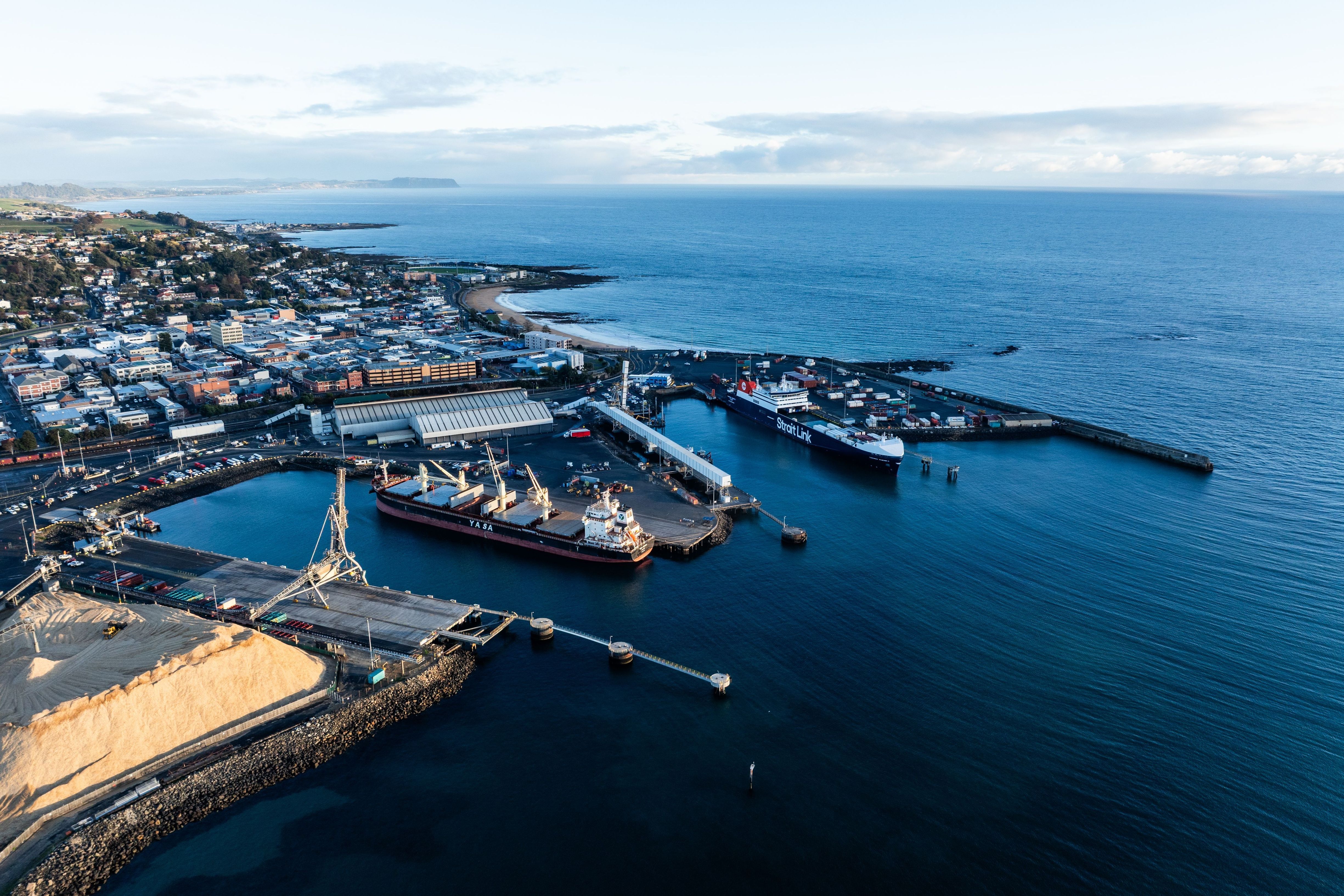 Aerial view of cargo ships docked at Burnie Port with the town and coastline beyond, north west
