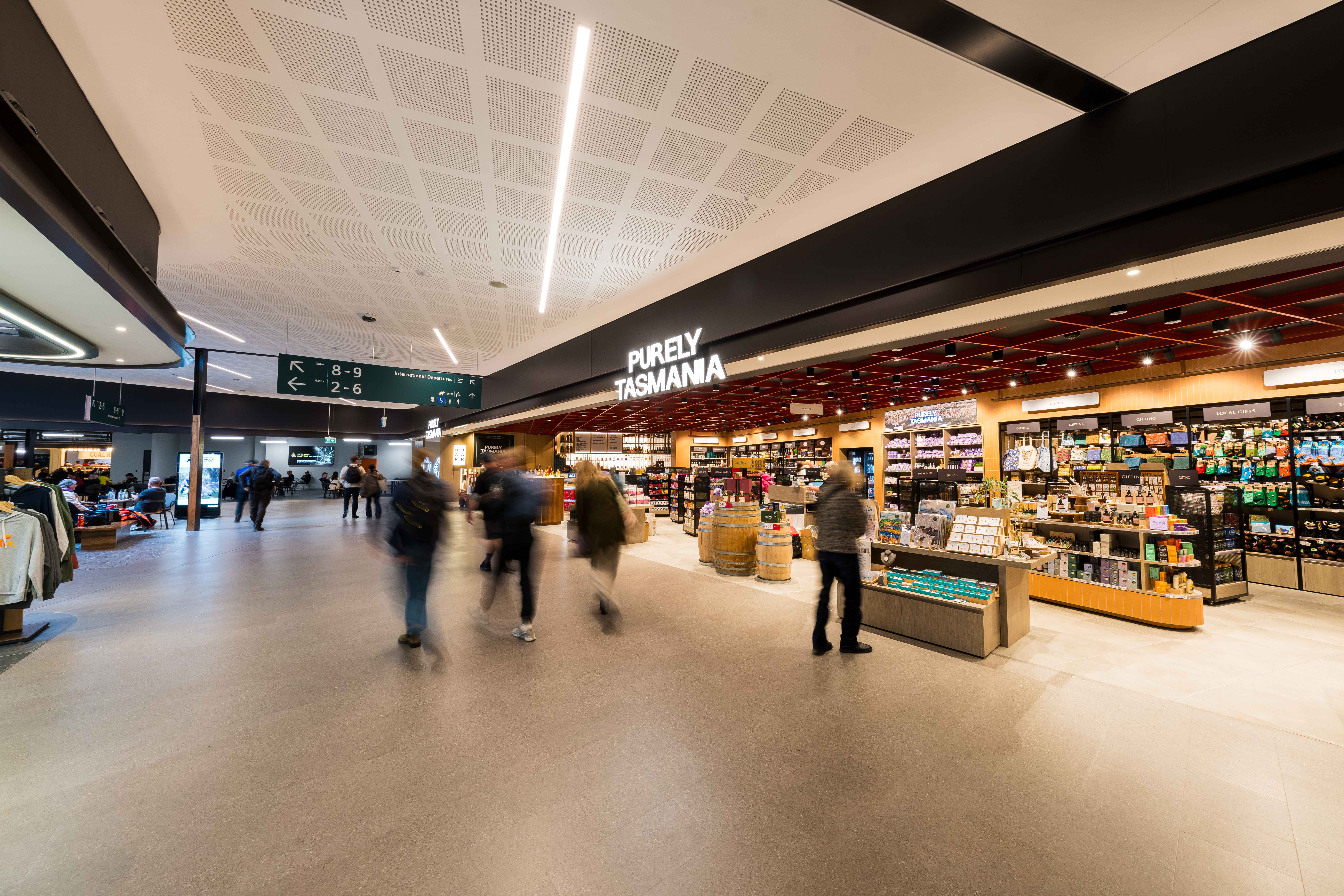 Travellers walk through Hobart International Airport terminal past the Purely Tasmania retail store stocked with local gifts