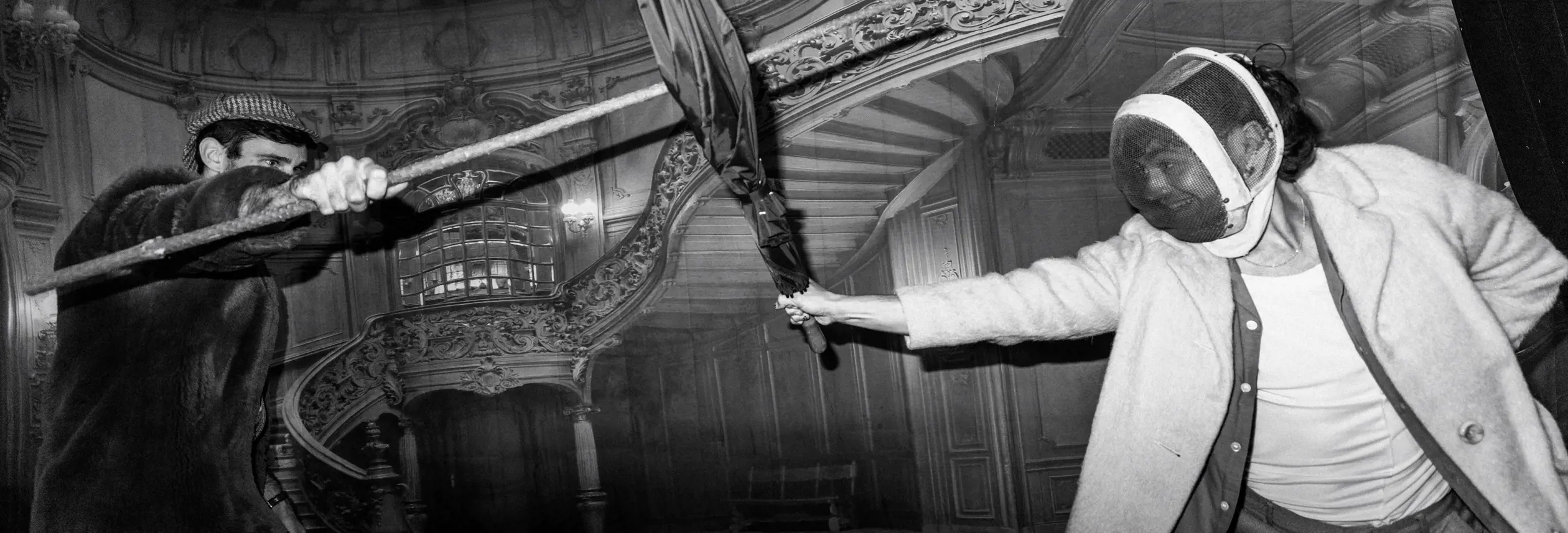 Black and white image of two people fencing with umbrellas in an ornate interior at The Secret Bank Society, Ringarooma
