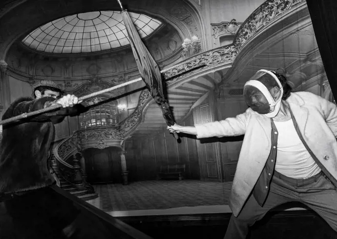 Black and white image of two people fencing with umbrellas in an ornate interior at The Secret Bank Society, Ringarooma