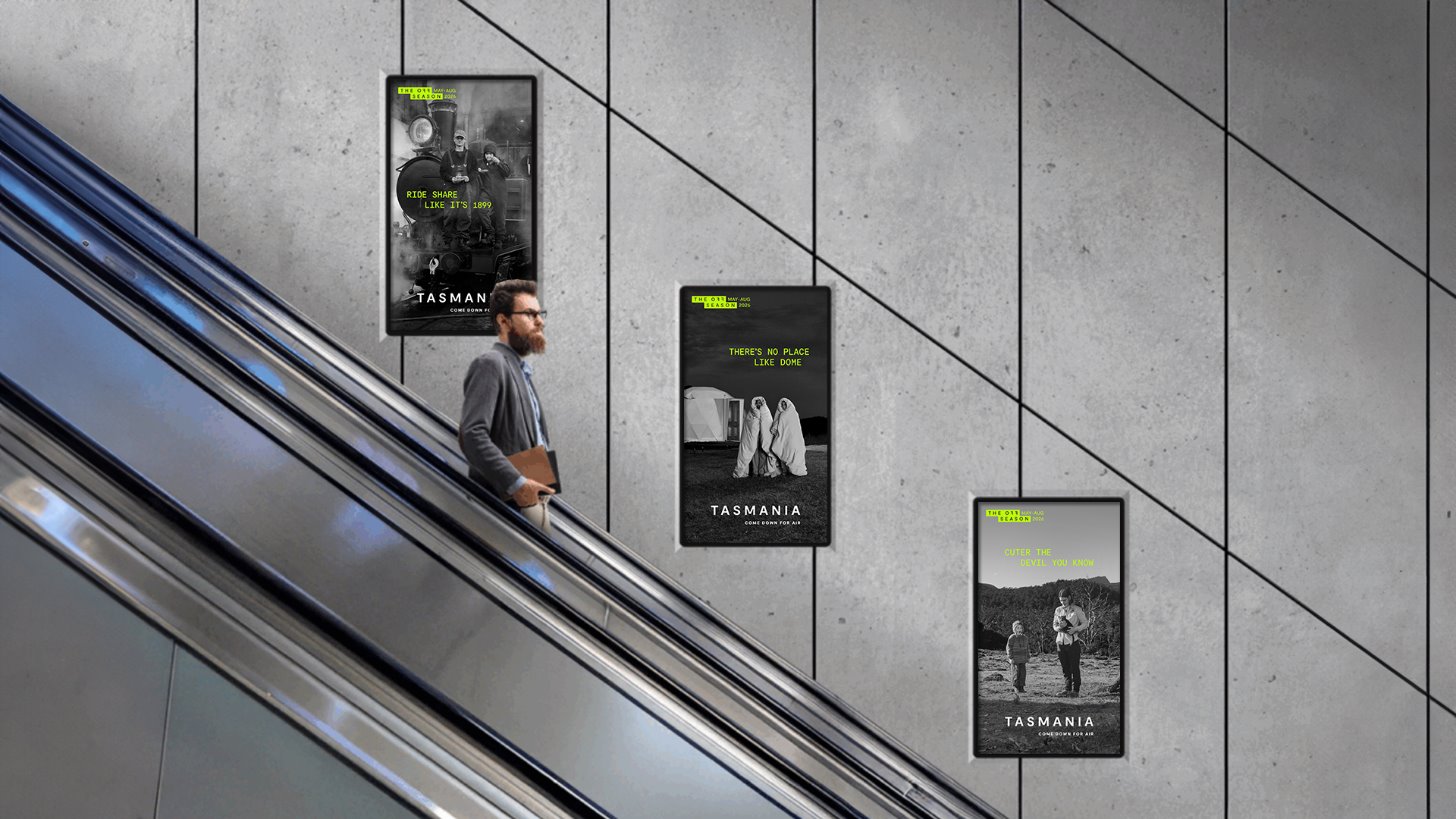 Three Tourism Tasmania Off Season campaign posters displayed along an escalator wall in a metro station