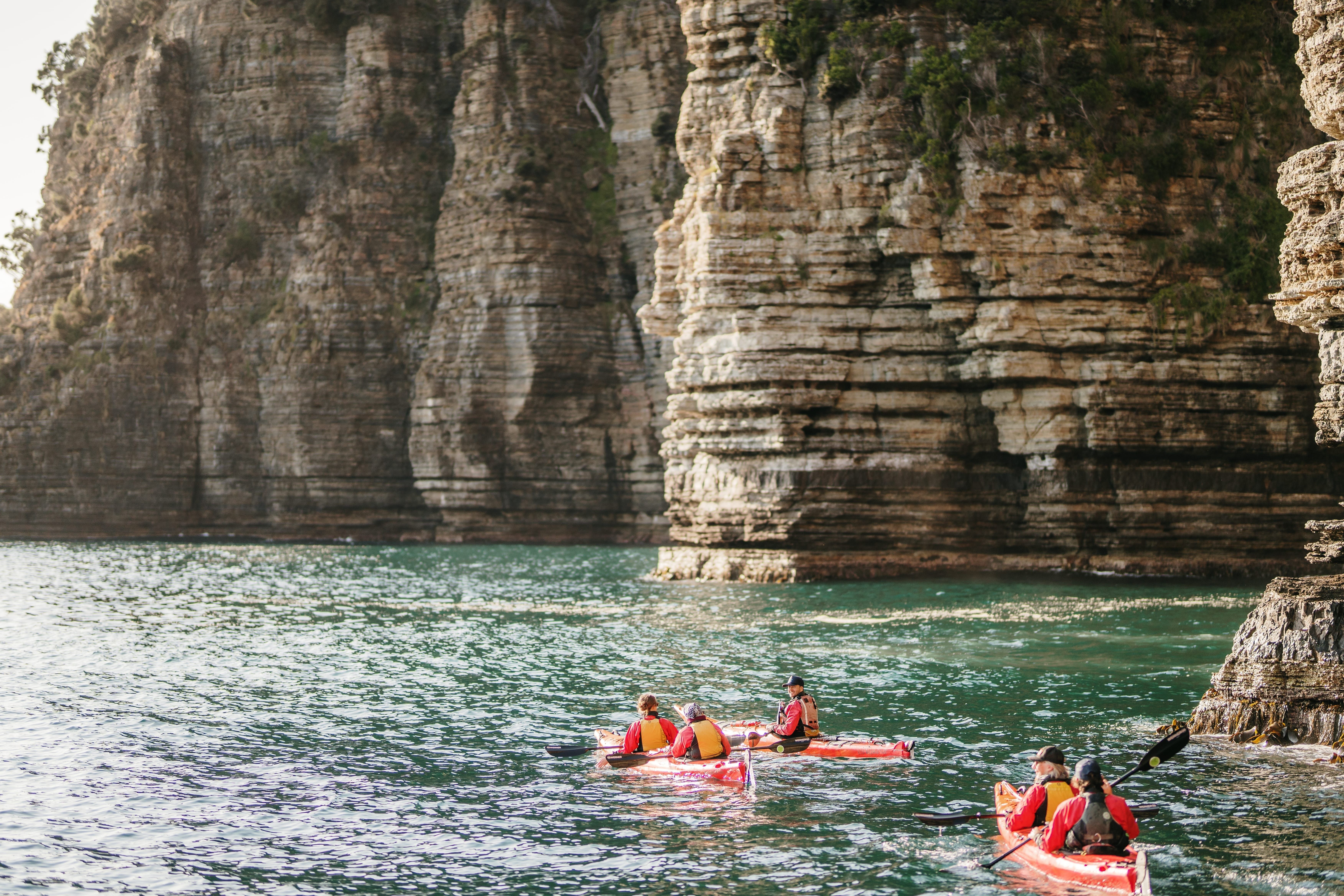 Sea kayakers paddle along dramatic coastal cliffs at Turrakana / Tasman National Park with Southern Sea VentureSea kayakers paddle along dramatic coastal cliffs at Turrakana / Tasman Peninsula with Southern Sea Ventures