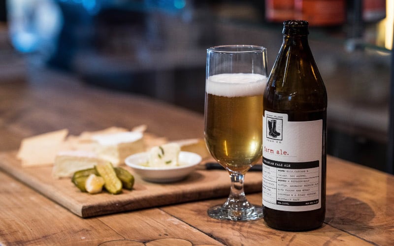 A Bruny Island Beer bottle and beer in a glass sitting on a wooden table