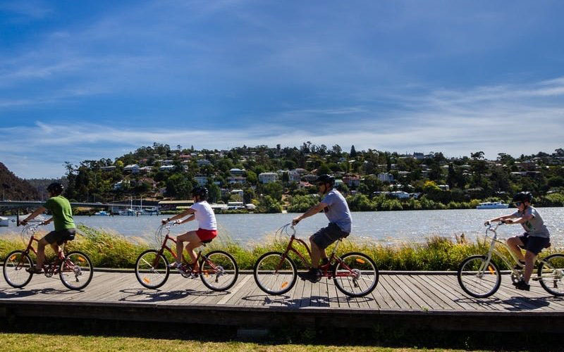 A family ride their bikes along the River Tamar on the wooden boardwalk