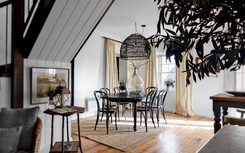 A photograph of a redecorated, two-bedroom apartment with modern furnishings is bathed in sunlight