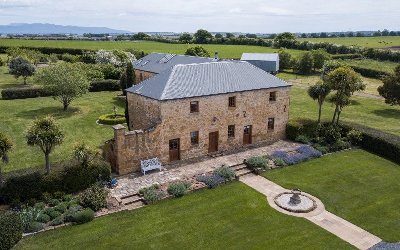 An elevated photograph of convict-era accommodation in lush green gardens