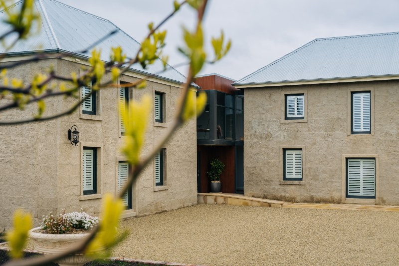 A sunny courtyward sits between the two lovingly restored colonial era buildings that make up the Triabunna Barracks.