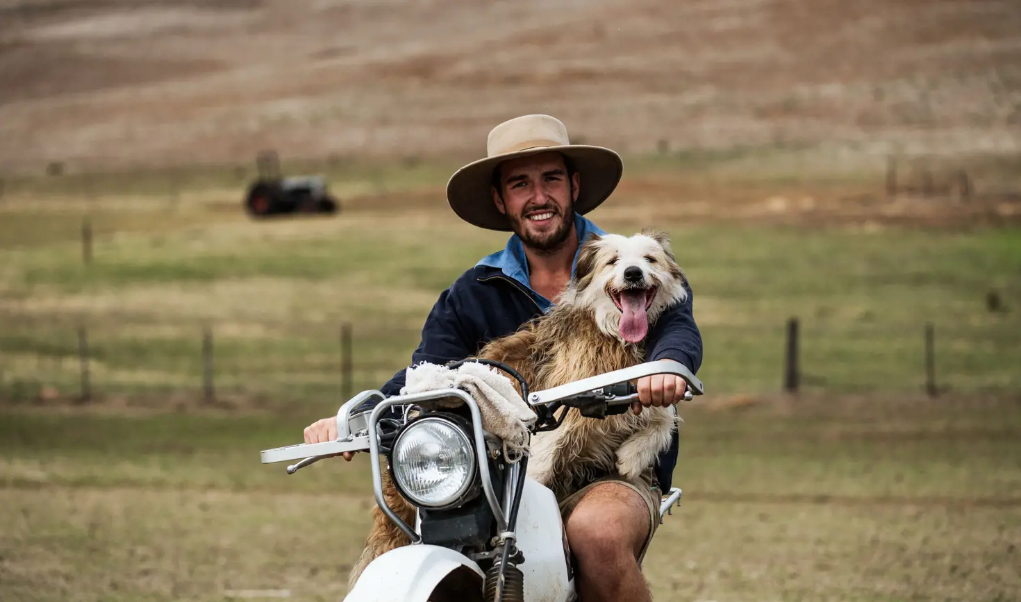 A farmer smiling with his working dog on a farm motorbike, Curringa Farm at Hamilton in Tasmania's Central Highlands